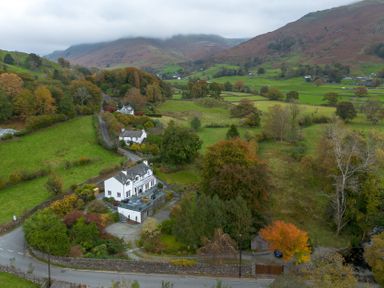 A house surrounded by fields and trees at Goody Raise in Grasmere