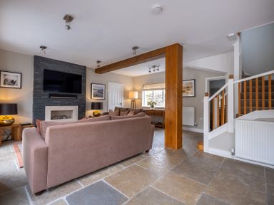 A living room with a television and sofa at Goody Raise in Grasmere