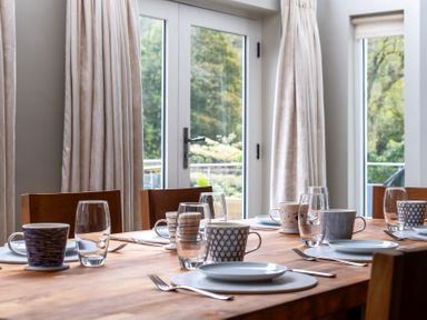 A dining room with a table set for meals at Goody Raise in Grasmere
