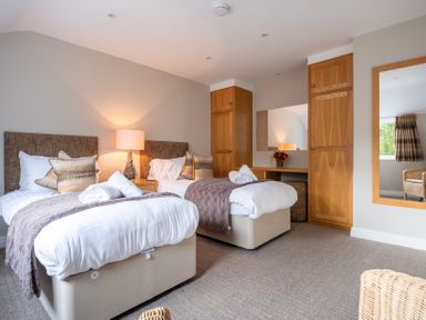 A bedroom with twin beds and a mirror at Goody Raise in Grasmere