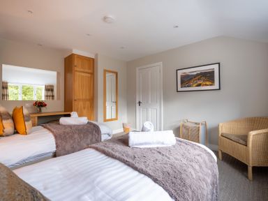 A bedroom with two beds and a mirror at Goody Raise in Grasmere