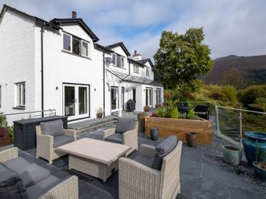 A house with a deck and seating area at Goody Raise in Grasmere