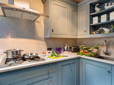 A kitchen corner with stove pots vegetables and kitchen appliances at Acorn Cottage in Grasmere