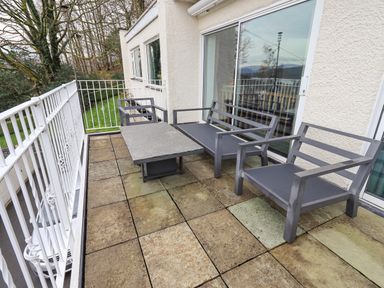 A balcony with metal outdoor furniture and a tiled floor at Tanna Hill in Bowness