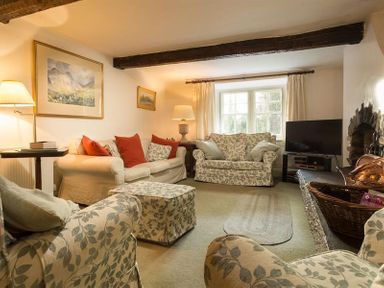 A living room with sofas and a television by a window at High Cleabarrow in Windermere
