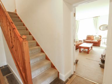 A hallway with stairs and a view of the living room at Hawkshead Hall in Hawkshead