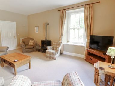 A living room with a sofa and armchair at Hawkshead Hall in Hawkshead