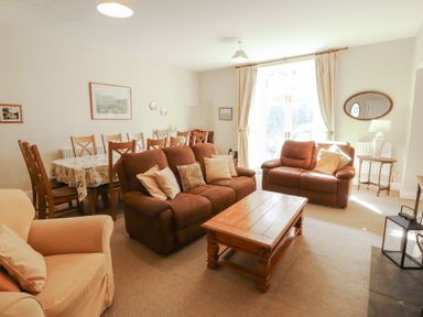 A living room with a sofa and dining table at Hawkshead Hall in Hawkshead
