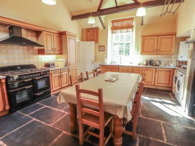 A kitchen with a dining table and appliances at Hawkshead Hall in Hawkshead