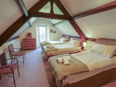 A bedroom with three beds and a dresser at Hawkshead Hall in Hawkshead