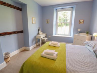 A bedroom with a bed and desk at Hawkshead Hall in Hawkshead