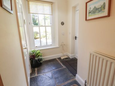A hallway with a window and a plant at Hawkshead Hall in Hawkshead