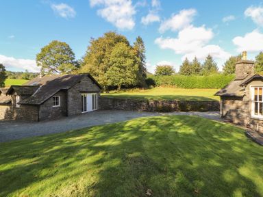A house with a gravel pathway and lawn at Hawkshead Hall in Hawkshead