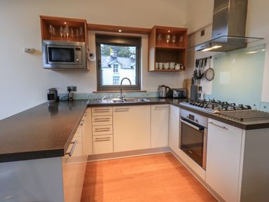 A kitchen with a stove oven microwave sink and window at Idle Mill 2 in Ambleside