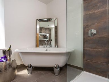 A bathroom with a freestanding bathtub clawfoot tub and a glass shower enclosure at Fell Cottage in Ambleside