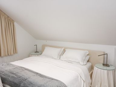 A bedroom with a bed two pillows and bedside tables with lamps at St Julien in Dawlish