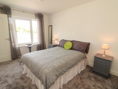 A bedroom with a bed and two bedside tables with lamps at Coolnaharragill Lower Annexe in Glenbeigh County Kerry
