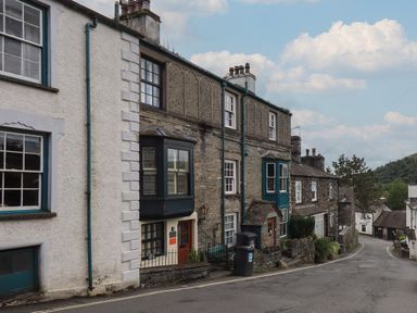 A street with stone and plaster houses with bay windows and chimneys in a village