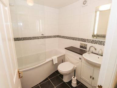 A bathroom with a bathtub toilet sink and a mirror at Waterfalls in Ambleside