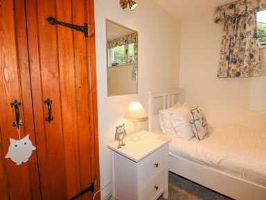 A small bedroom with a single bed and floral curtains at Highfold in Ambleside