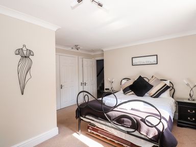 A bedroom with a metal bed frame pillows bedside tables and wall art at Ghyll View in Ambleside