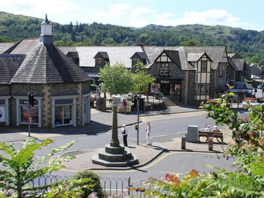A street with stone and timber buildings and a small monument in the center at Bield How in Ambleside