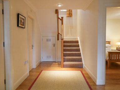 A hallway with stairs and doors leading to other rooms at Orchard House in Ambleside