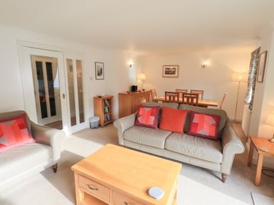 A living room containing a sofa and dining table at Mardale in Ambleside