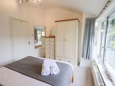 A bedroom with a bed and wardrobe at Mardale in Ambleside