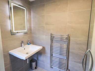 A bathroom with a wash basin and mirror at Mardale in Ambleside