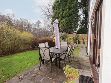 A garden with a dining table and chairs at Mardale in Ambleside