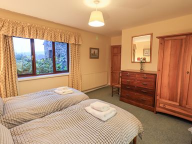 A bedroom with two single beds a wooden dresser and a wardrobe at Low House Ullswater
