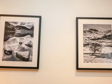 Two black and white framed landscape photographs hanging on a white wall at Fir Howe in Skelwith