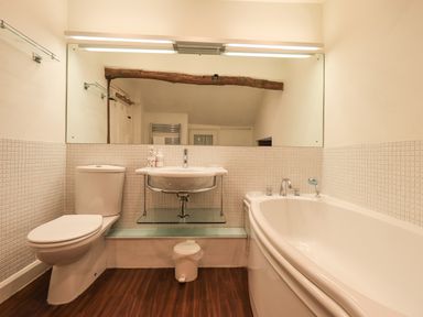 A bathroom with a toilet sink bathtub and large mirror at Syke Cottage in Hawkshead