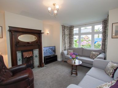 A living room with sofas a wooden coffee table and a fireplace at Fell End in Keswick