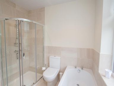 A bathroom with a glass shower enclosure a white toilet and a bathtub at Fell End in Keswick