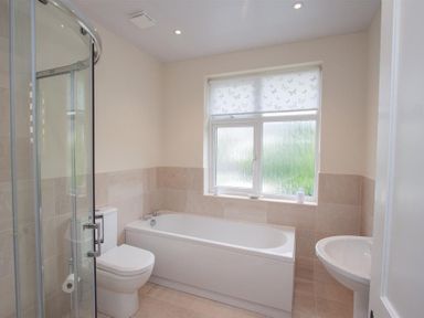 A bathroom with a bathtub toilet shower and sink at Fell End in Keswick