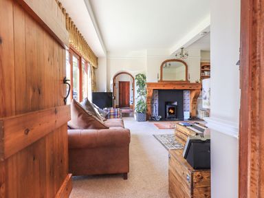 A living room with a sofa a fireplace and wooden furniture at The Stables in Ambleside