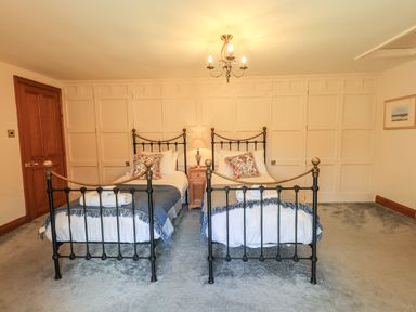 A bedroom with two single beds and a nightstand between them at The Stables in Ambleside