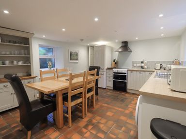 A kitchen with a dining table and appliances at Chapel Hill Cottage in Ambleside