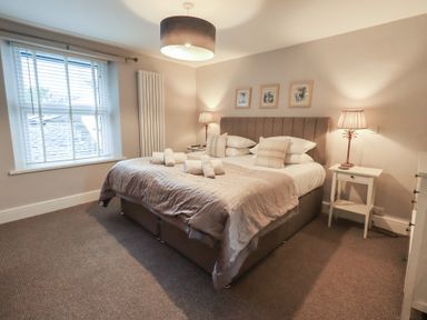 A bedroom with a bed and bedside tables at Chapel Hill Cottage Ambleside