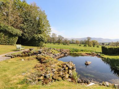 A garden with a pond and bench at South View in Keswick