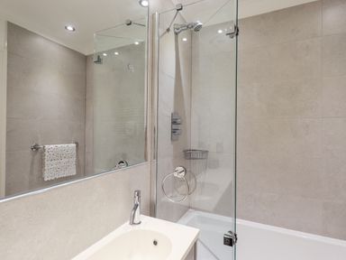 A bathroom with a sink a mirror a shower and a towel on a rack at Fairview in Bowness