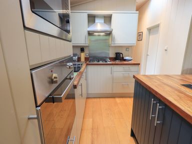 A kitchen with wood countertops an oven a sink a kettle and a stovetop at Beck of Beyond in Ambleside