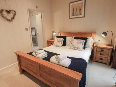 A bedroom with a wooden bed and nightstands with lamps at Beck of Beyond in Ambleside