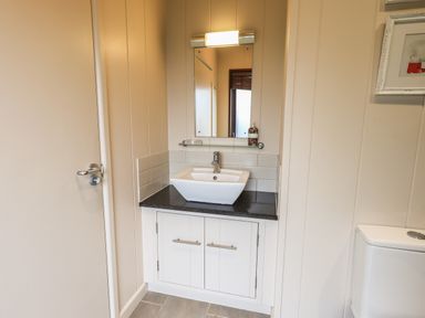 A bathroom sink with a mirror above and a toilet partially visible at Beck of Beyond Ambleside