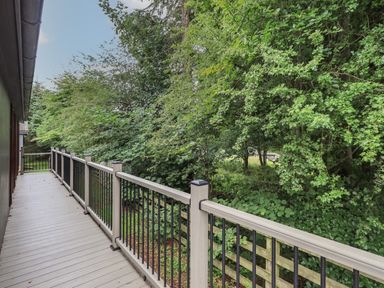 A balcony with railings overlooking trees and greenery at Beck of Beyond in Ambleside