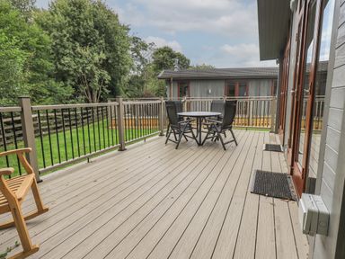 An outdoor deck with a round table and four chairs surrounded by a railing at Beck of Beyond in Ambleside