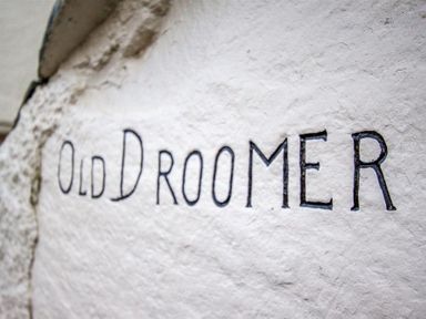A close up of the text Old Droomer engraved on a textured white surface at Old Droomer in Windermere