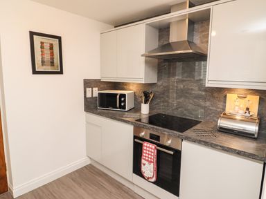 A kitchen with microwave oven stovetop and bread box at Kirkstones in Keswick
